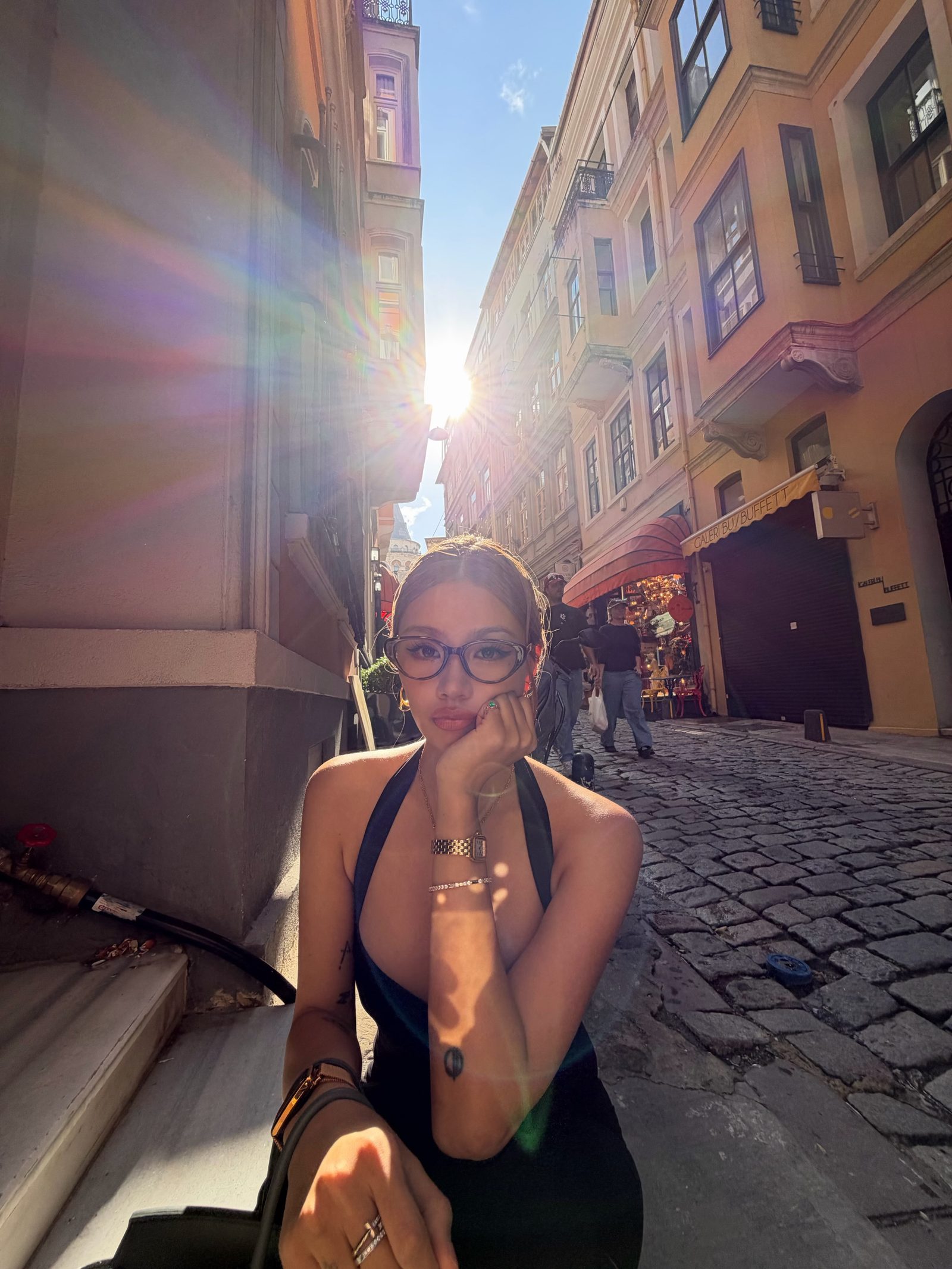 Kathy Zheng in glasses with a sun flare over an old street
