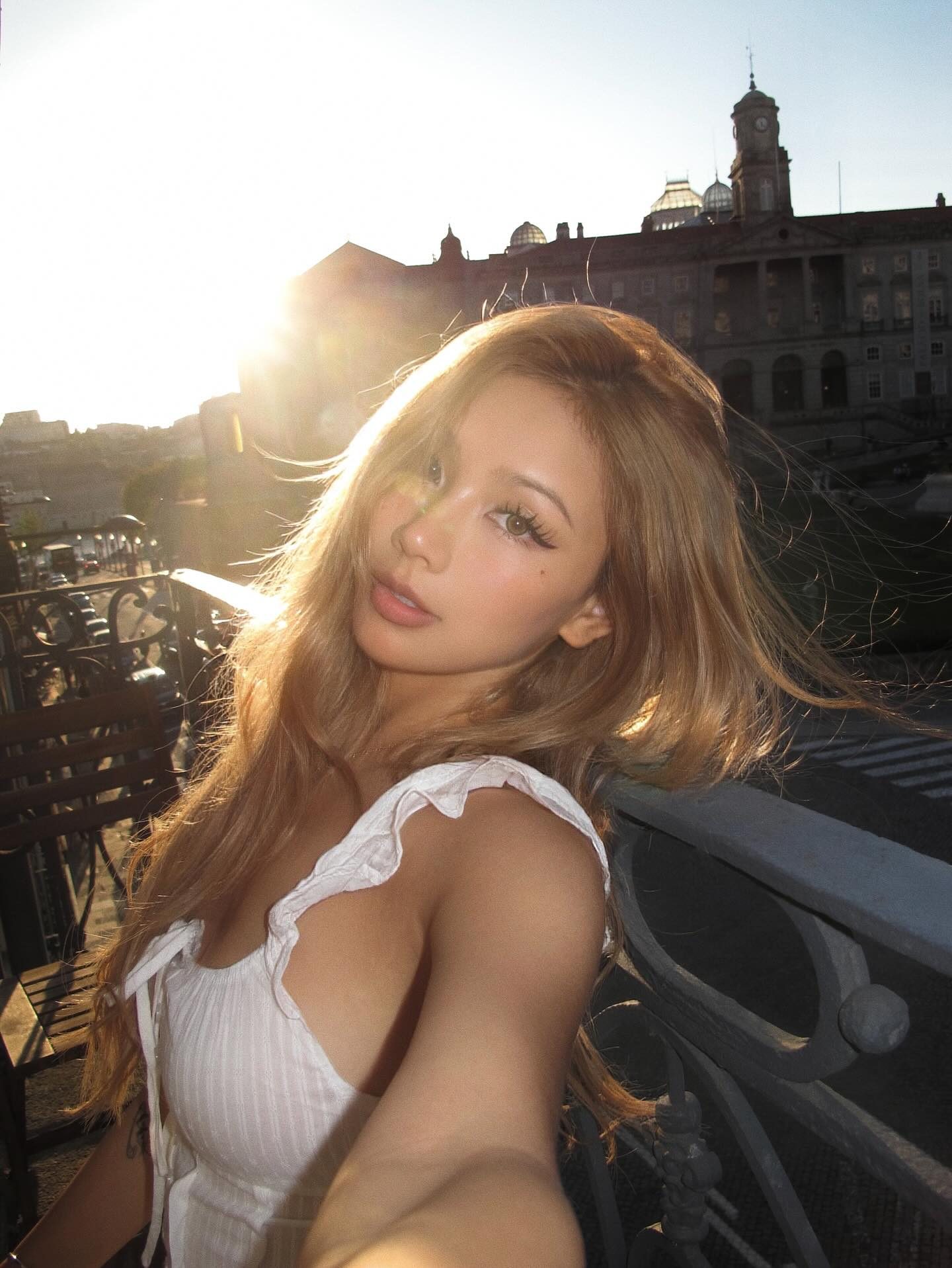 Kathy Zheng with sunlit golden hair and a lens flare above Porto