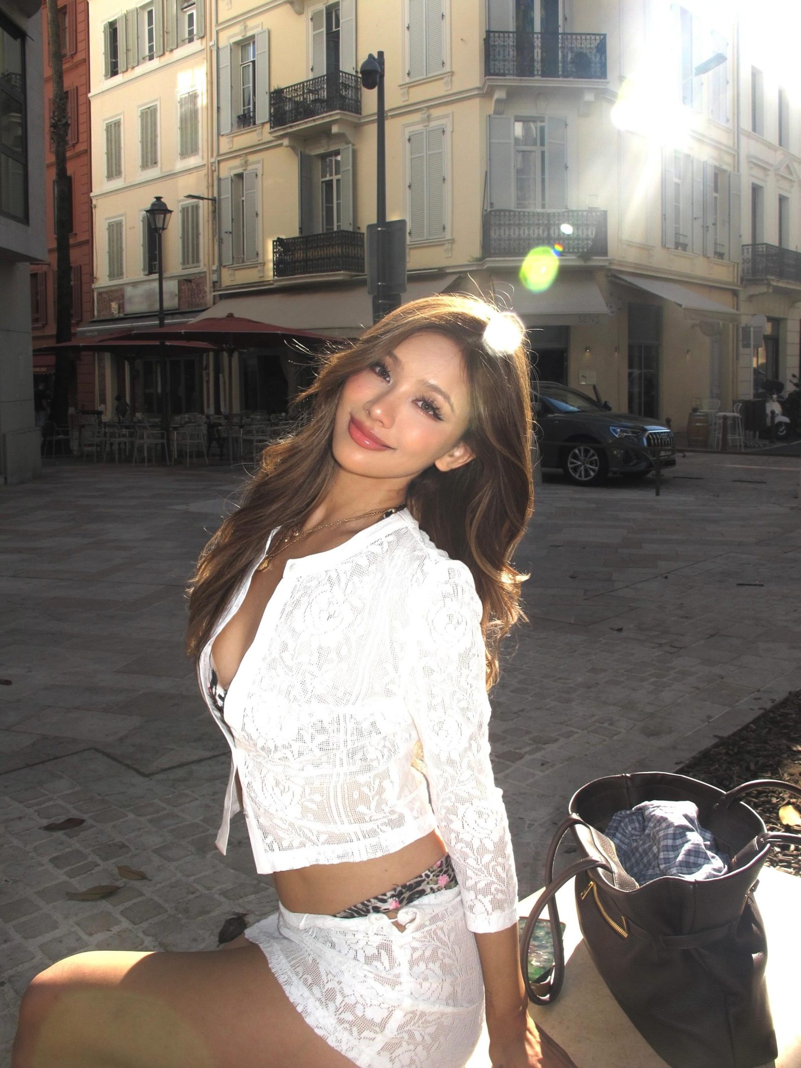 Kathy Zheng in white lace on a sunlit street